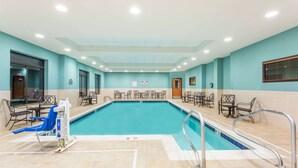 A swimming pool with a blue chair and a lifeguard stand. - Wingate by Wyndham Richmond Short Pump (Richmond)