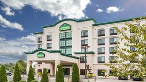 A Wingate by Wyndham hotel with a modern facade, multiple balconies, and a clear sky. - Wingate by Wyndham Richmond Short Pump (Richmond)