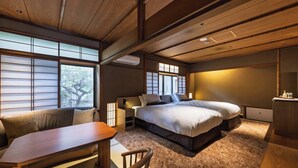 A traditional Japanese-style room with tatami flooring, a low wooden ceiling, and sliding shoji doors.