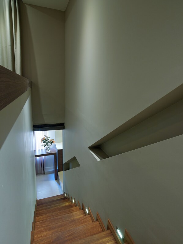 A staircase with wooden steps and a wall with built-in shelves. - Elotis Suites (Chania)