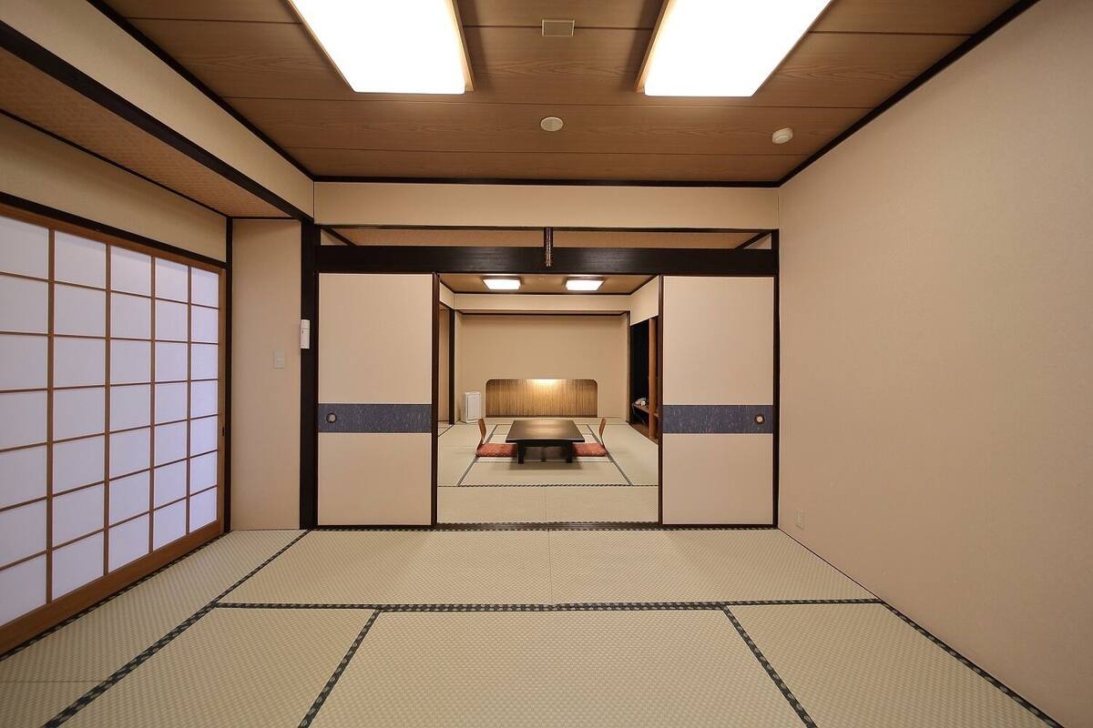 Ein traditioneller japanischer Raum mit Tatami-Böden, einem niedrigen Tisch und Schiebetüren.