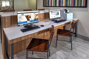 Un mostrador de recepción con dos monitores de computadora, un teclado y un ratón.