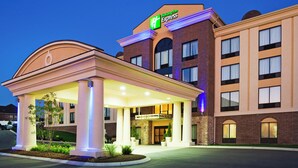 Een Holiday Inn Express hotel met een overdekte ingang, een gevel van baksteen en verlichte borden.