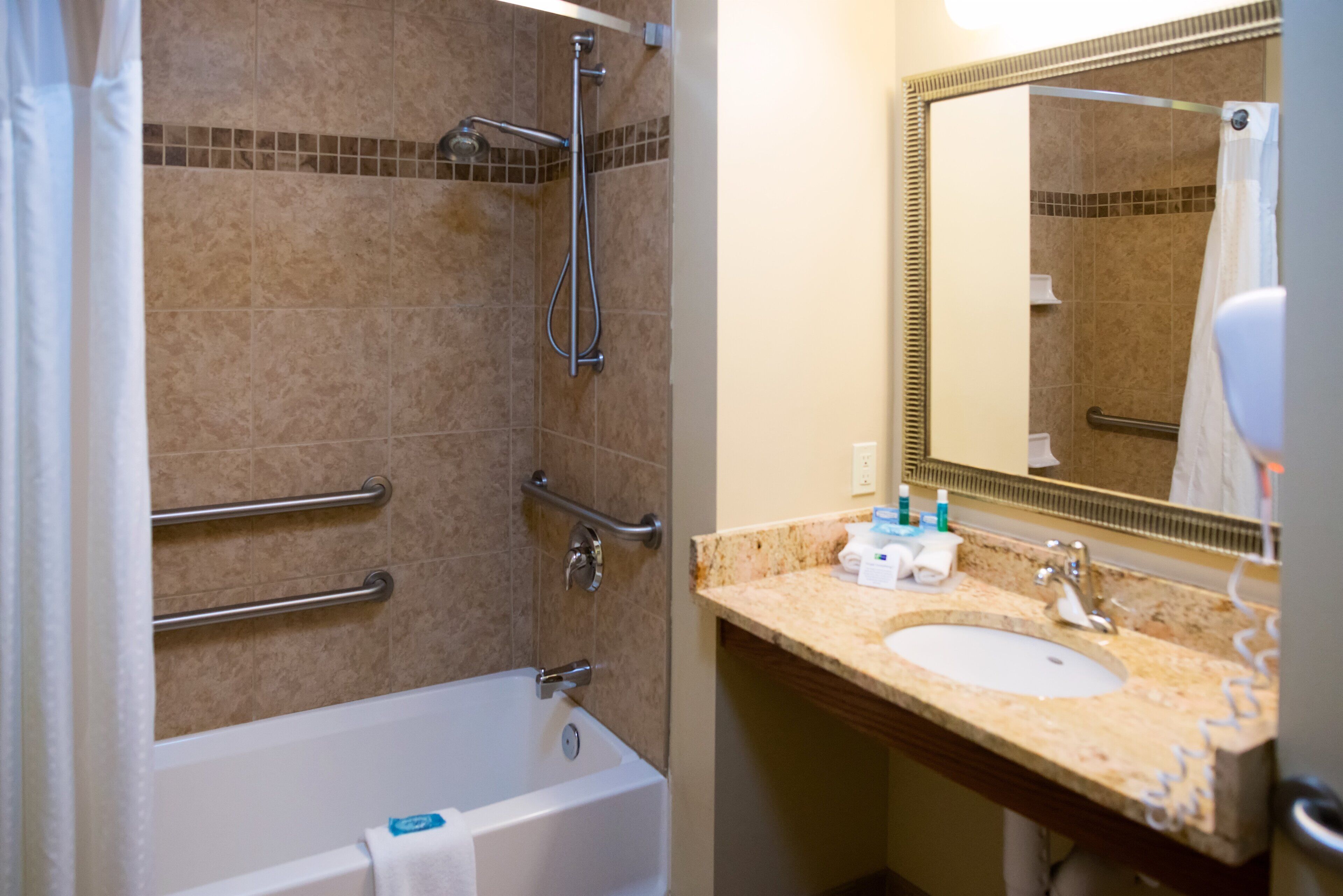 A bathroom with a bathtub, shower, and sink.