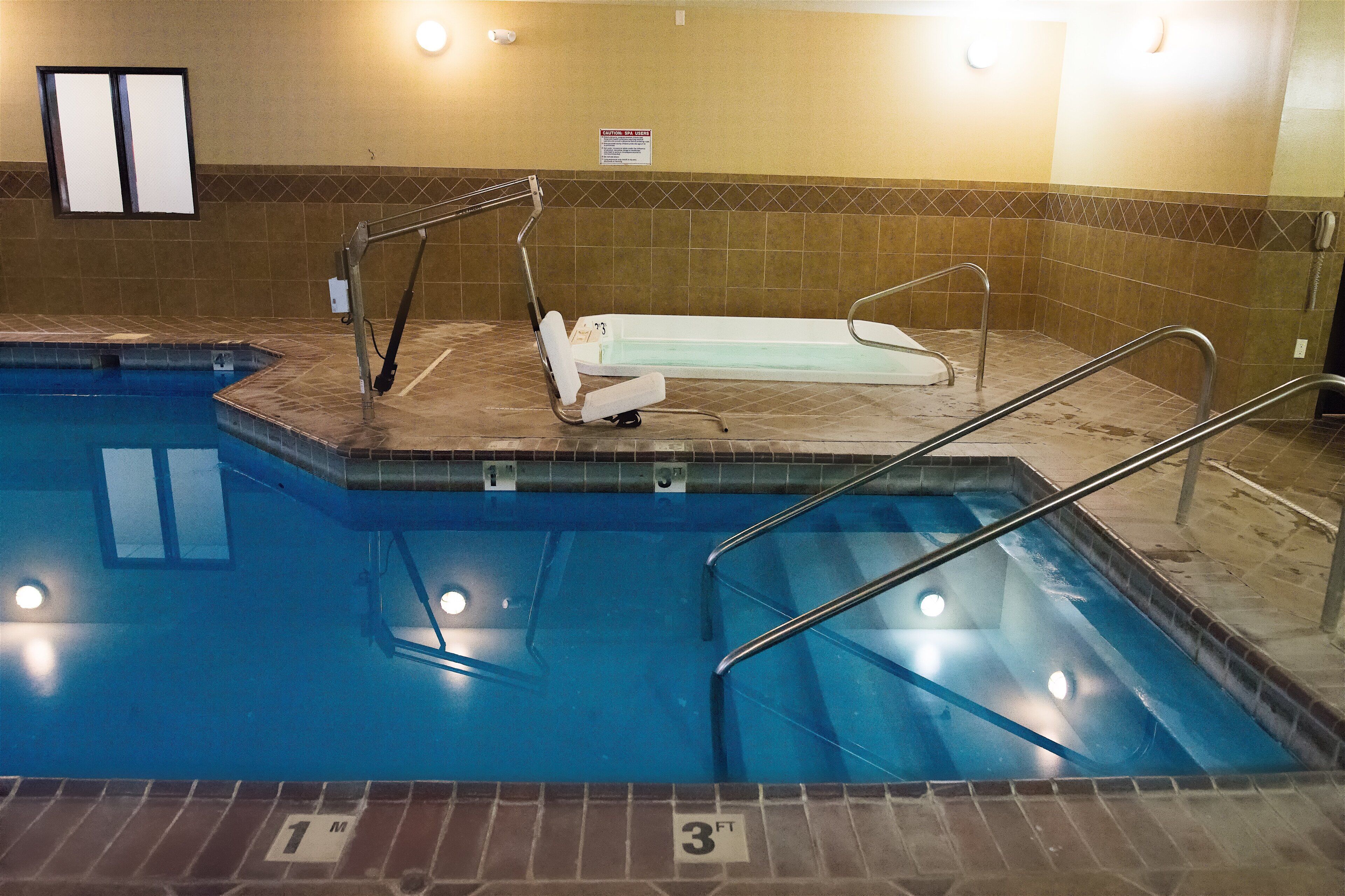 A swimming pool with a diving board and a lifeguard stand.