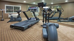 A gym with multiple treadmills, stationary bikes, and a rowing machine.