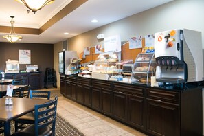A breakfast buffet area with various food stations, including a coffee machine and a refrigerator with beverages. - Holiday Inn Express Devils Lake by IHG (Devils Lake)