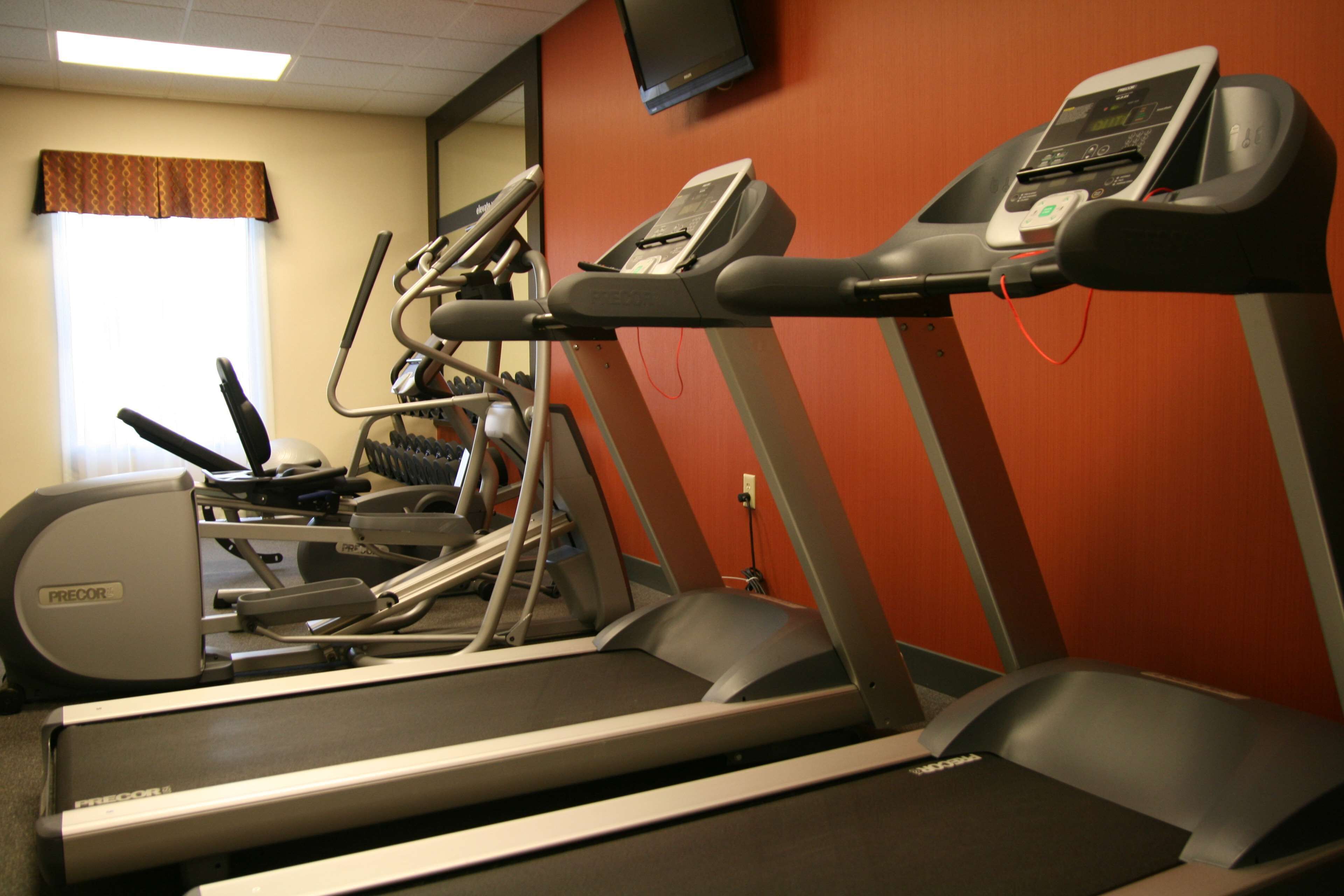 Un gimnasio con cintas de correr y elípticas.