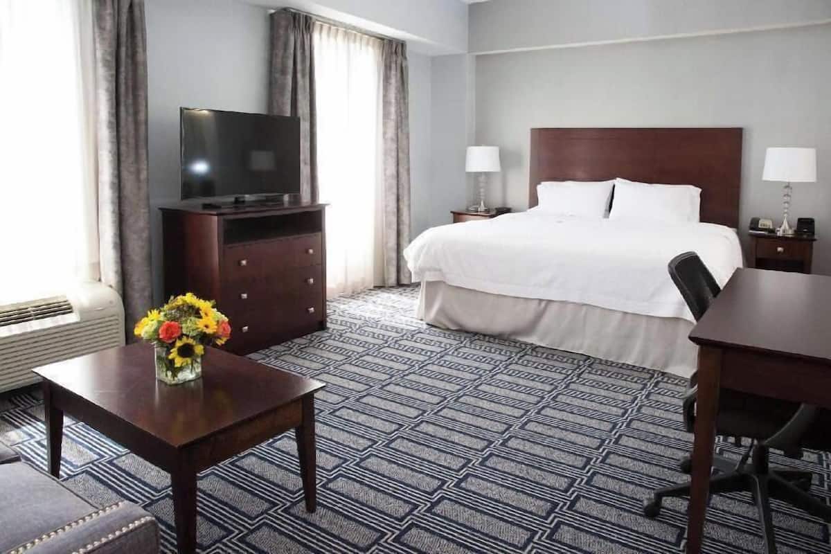 Une chambre d’hôtel avec un lit, une télévision, un bureau et une chaise.