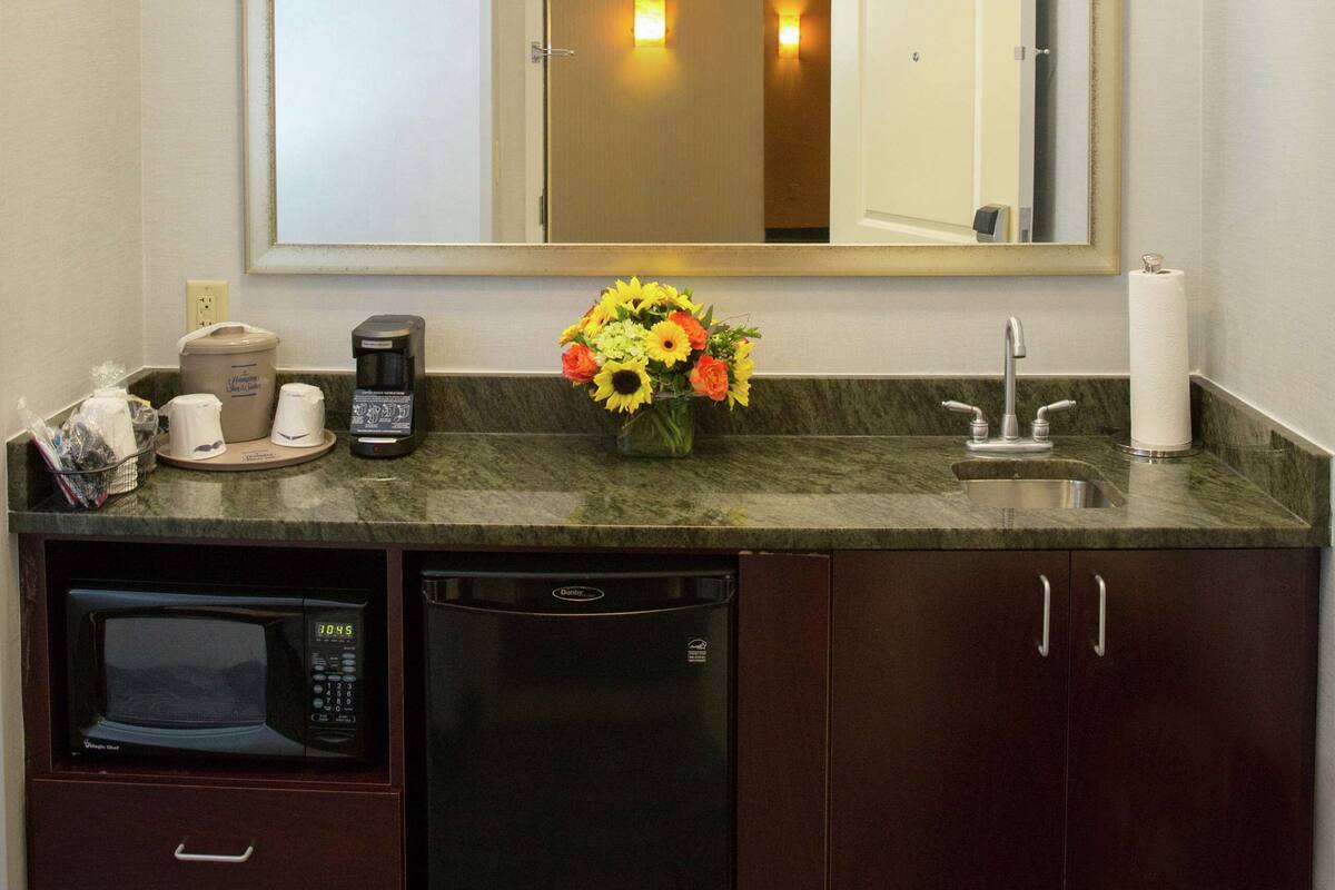 Une salle de bain compacte équipée d’un four à micro-ondes, d’une machine à café et d’un lavabo.