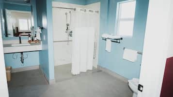 A bathroom with a shower, toilet, and sink.