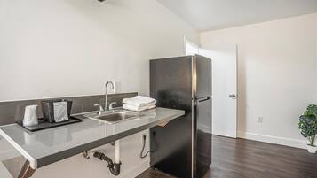 A modern kitchen with a stainless steel refrigerator, a sink, and a countertop.