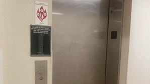 An elevator with a digital display showing the number 4, emergency instructions, and a fire exit sign. - HomeTowne Studios & Suites by Red Roof Bentonville (Bentonville)