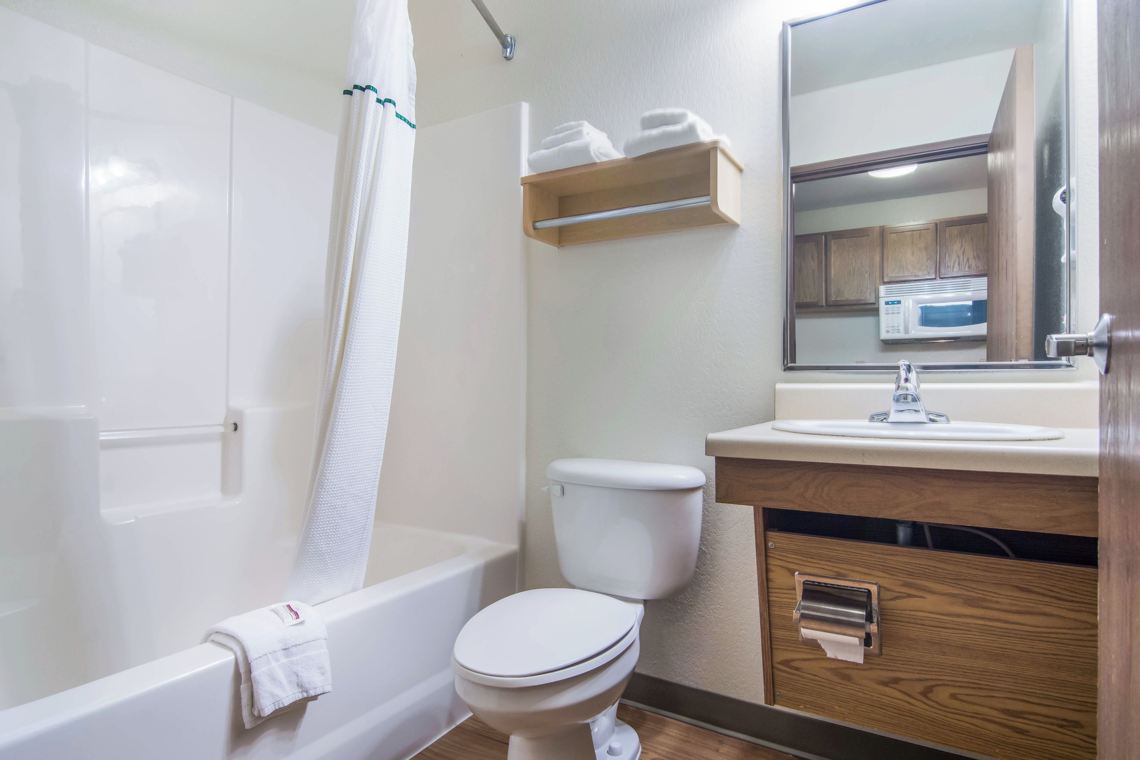 A bathroom with a bathtub, toilet, sink, and a mirror.