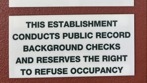 A sign with check-out and check-in times, a no pets policy, and a note about a required customer deposit. - HomeTowne Studios & Suites by Red Roof Bentonville (Bentonville)