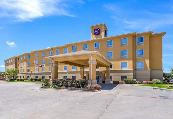 A hotel with a covered entrance, multiple floors, and a sign indicating it is a Sleep Inn Express.