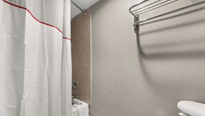 A bathroom with a white bathtub, a shower curtain, and a toilet. - Red Roof Inn Memphis - Graceland/ Airport (Memphis)