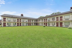 A motel with a central courtyard, multiple balconies, and a symmetrical facade.