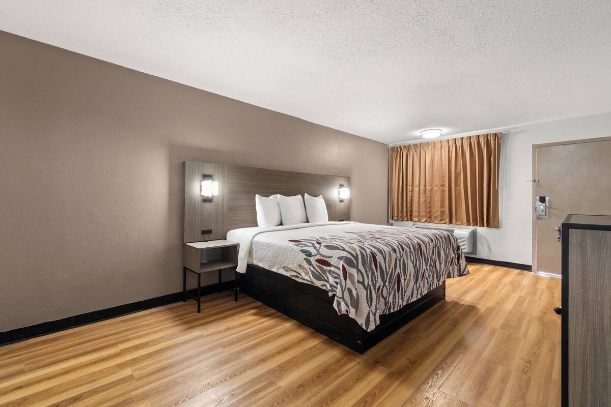 Ein Hotelzimmer mit Bett, Nachttisch und Kleiderschrank.