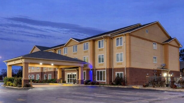 A multi-story hotel with a covered entrance and a parking lot. - Springplace Inn & Suites (Marion)