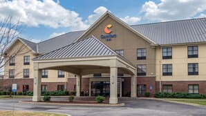 A Comfort Inn hotel with a covered entrance, brick facade, and a clear sky. - Comfort Inn Louisville Southwest (Louisville)