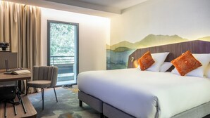 Una camera d'albergo con un letto, una scrivania, una sedia e vista sull'esterno.