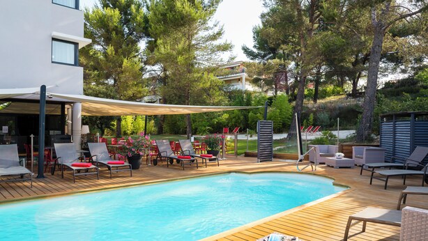 Una piscina con lettini e un tavolino con bevande e snack.