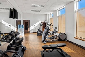 A gym with exercise equipment, a television, and large windows. - Comfort Suites Frisco (Frisco)