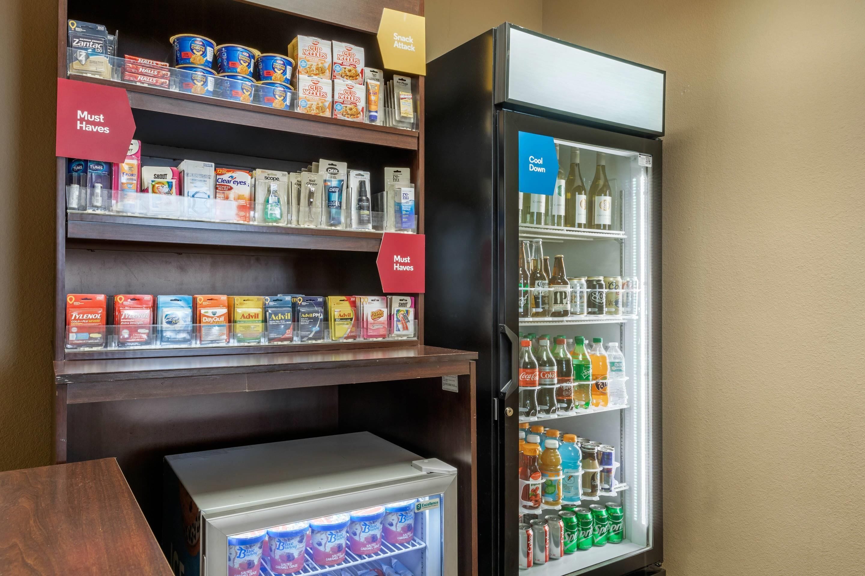 A hotel minibar with snacks, beverages, and a refrigerator.