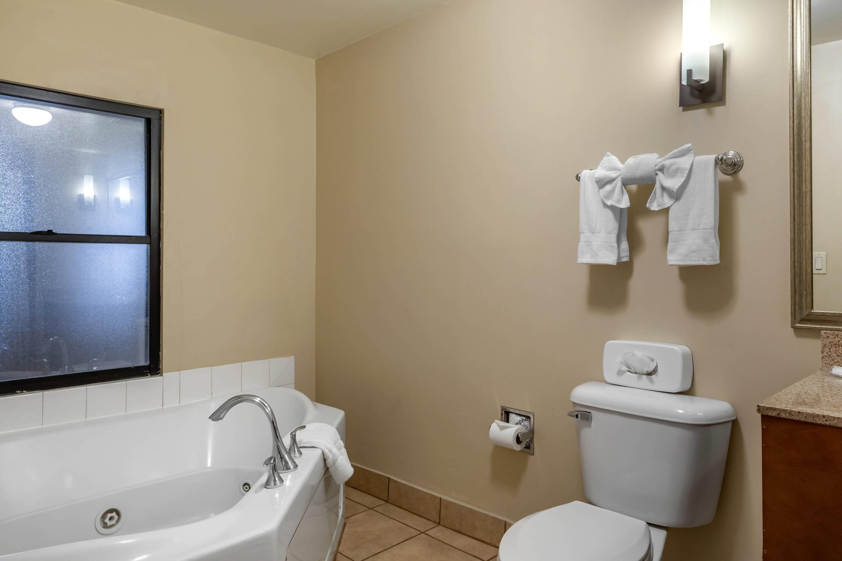 A bathroom with a bathtub, toilet, and towel rack.