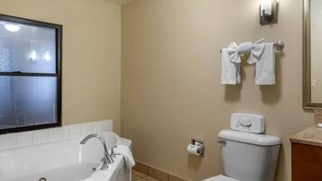 A bathroom with a bathtub, toilet, and towel rack.