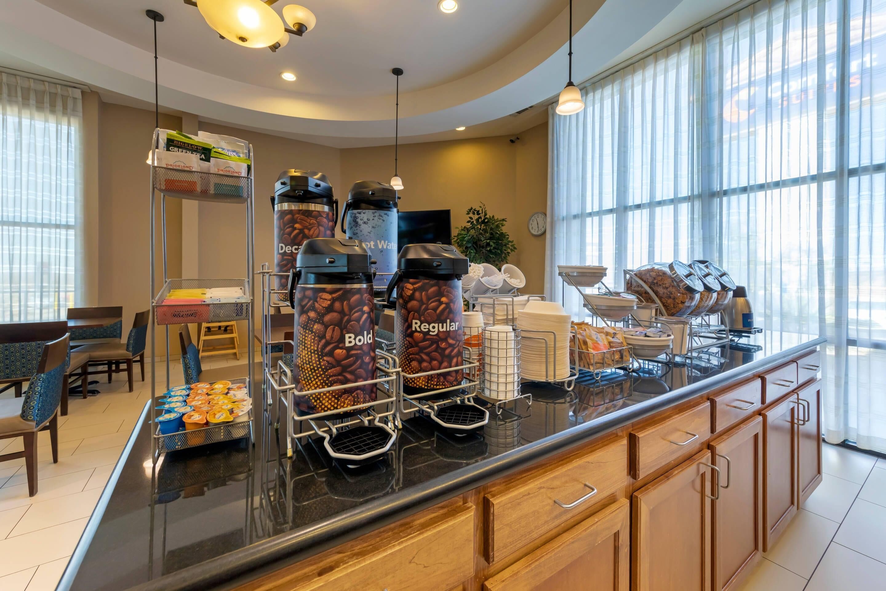 Un espace dédié au café, avec des distributeurs à l’effigie de la marque, un buffet et un coin salon avec des chaises.