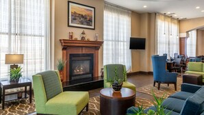 Un hall d’hôtel doté d’une cheminée, de sièges confortables, d’un téléviseur et d’un espace bureau.