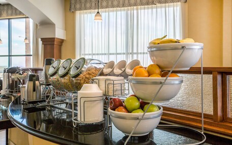 A breakfast buffet with various fruits, cereals, and beverages.