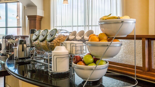 Un buffet de petit-déjeuner proposant une variété de fruits, de céréales et de boissons.