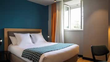 Una camera d'albergo con un letto, una sedia, una finestra e un comodino.