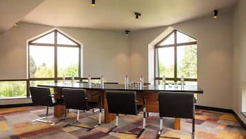 Una sala conferenze con un lungo tavolo, quattro sedie e ampie finestre.