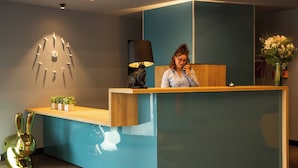 En reception med et moderne design, et vægur og en lampe.