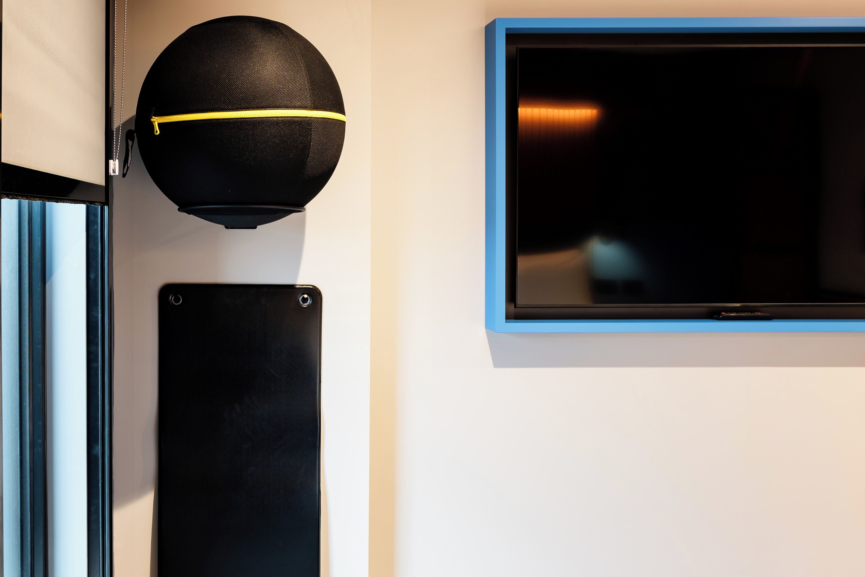 Een zwarte speaker en een flatscreentelevisie bevestigd aan een muur.
