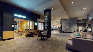 A spacious lobby with a Starbucks, Village Gym, and a Pub & Grill area. - Village Hotel Leeds South (Leeds)