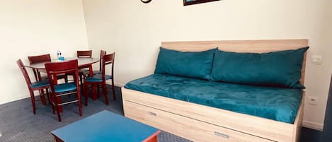 Una habitación pequeña con una cama, una mesita y una silla.