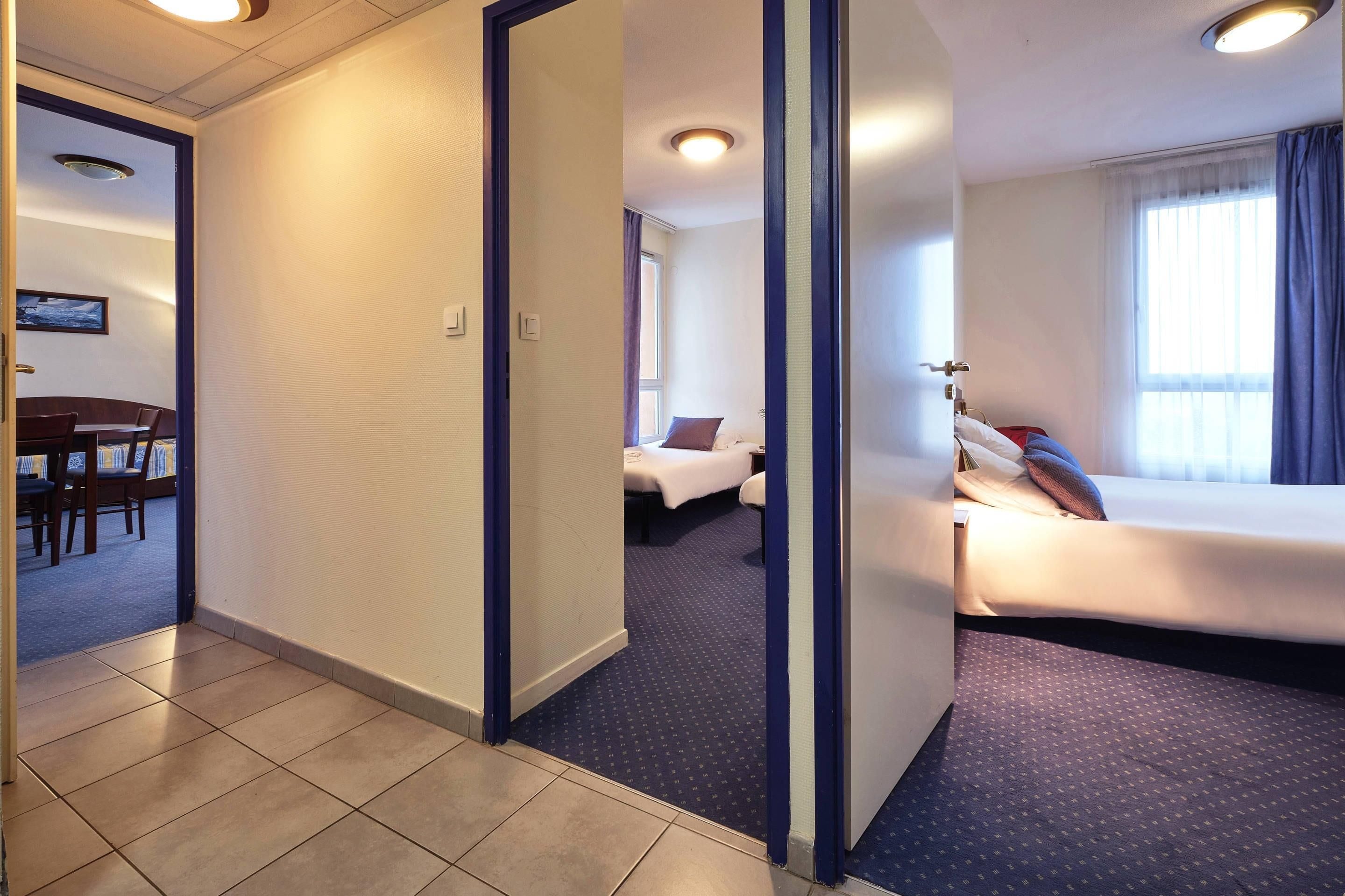 A hotel room with a bed, a desk, and a chair.