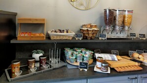 A breakfast buffet with various food options, including cereals, jams, and pastries. - Comfort Aparthotel Carcassonne (Carcassonne)