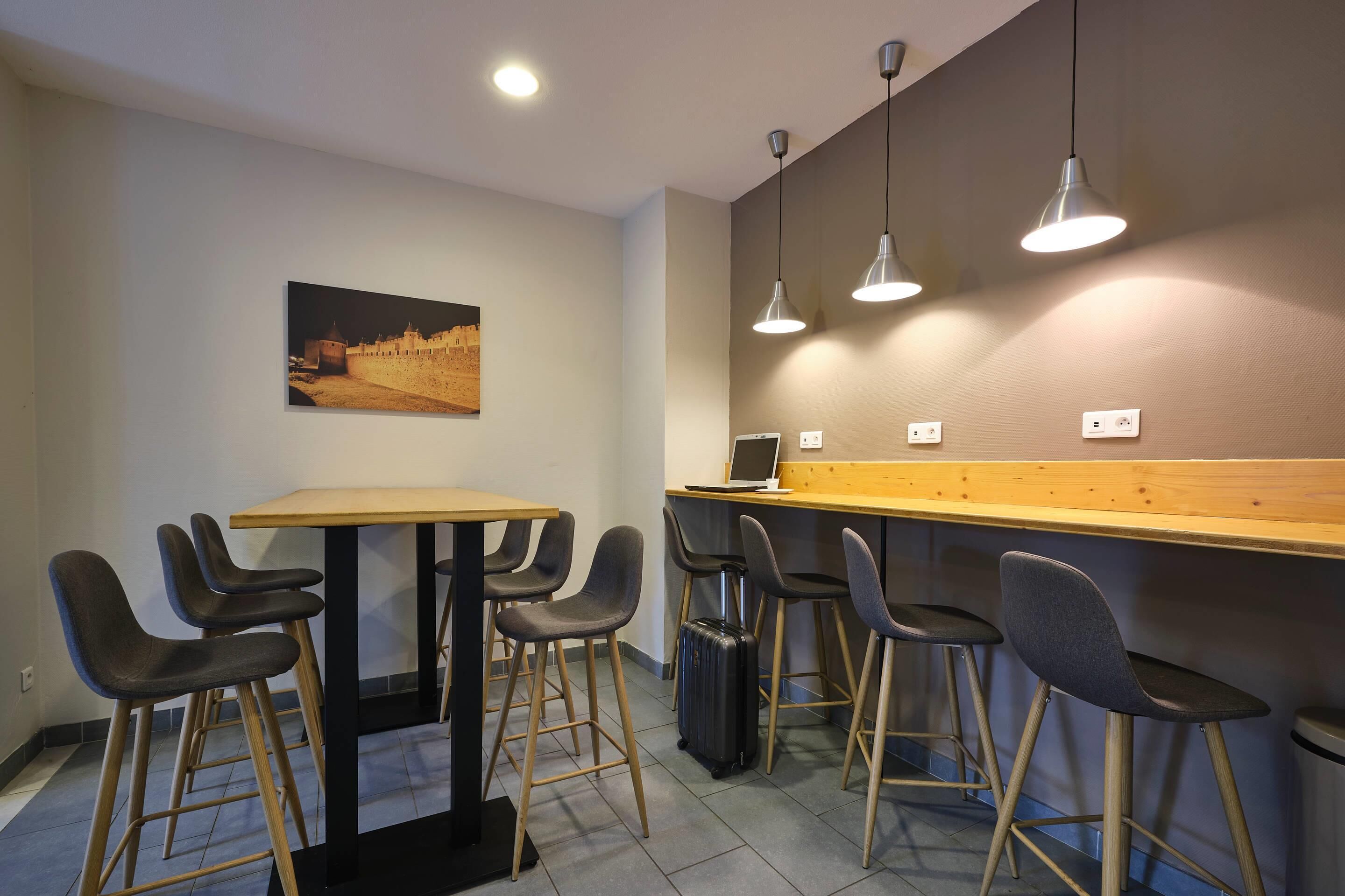 Eine moderne Bar mit einer Holztheke, mehreren Barhocker und Pendelleuchten.