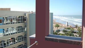 Ein Balkon mit Blick auf das Meer und den Strand.