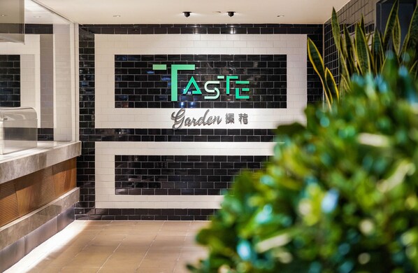 A modern interior with a black and white tiled wall, a sign reading "TASTE Garden", and a plant in the foreground. - Pullman Shanghai Central-in XinTianDi & Yu Garden Area (Shanghai)