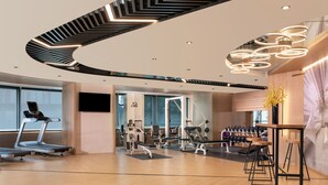 Una gimnàstica moderna amb equip de cardio, aparells de musculació i una zona amb barra de fusta.