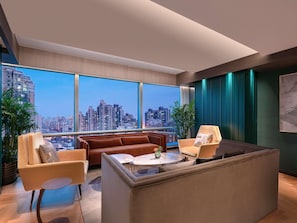 A modern living room with a city view, a sofa, a coffee table, and a large window. - Pullman Shanghai Central-in XinTianDi & Yu Garden Area (Shanghai)