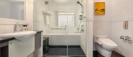 A modern bathroom with a glass-enclosed shower, a toilet, and a sink.