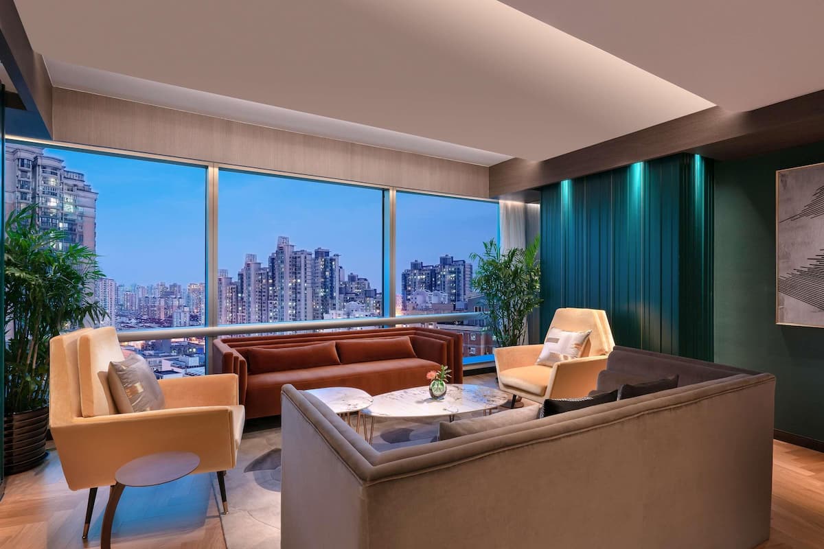 A modern living room with a city view, a sofa, a coffee table, and a large window.